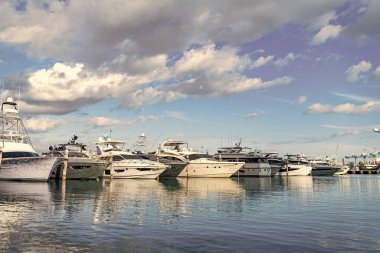 Lüks bir yat limanında. Güney sahil marinası. Denizdeki sürat teknesi. Yaz tatili. Lüks marina. Sefer teknesi denizde yüzüyor. Tekne turizmi. Deniz marinası. Lüks yat marinası..