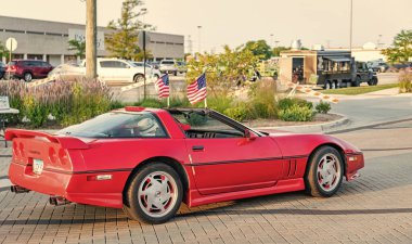 Park Ridge, Illinois, ABD - 22 Ağustos 2024: Sokakta önü görünen insanların olduğu üstü açık bir araba. Chevrolet Corvette C4 eski araba. Chevrolet Corvette C4 'ün üstü açık arabası. Chevy Corvette.