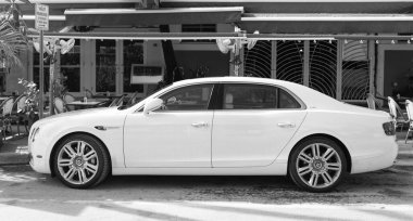 Miami, Florida, ABD - 17 Aralık 2024: 2016 Bentley Flying Spur Vur Sedan Car. Lüks araba beyaz Bentley Flying Spur V8 tipi. Bentley Uçan Mahmuz 'un arabası dışarıda park edilmiş. Bentley Uçan Mahmuz, yan görünüm.