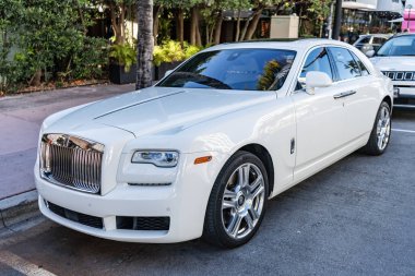 Miami, Florida, ABD - 27 Temmuz 2025: Rolls Royce Hayalet Serisi II 2015 ultra lüks sedan araba. Lüks SUV Rolls Royce Hayalet Serisi 2. Araba Hayalet Serisi 2 açık havada park edilmiş. Beyaz araba, köşe manzaralı.