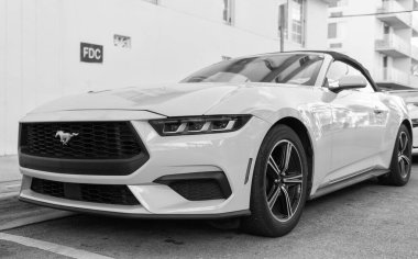 Miami, Florida, ABD - 15 Aralık 2024: Sarı 2024 Ford Mustang EcoBoost üstü açık araba. Ford Mustang 'in lüks arabası. Ford Mustang 'in arabası dışarıda park edilmiş. Ford Mustang sarı renk, köşe görünümü.