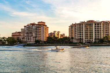 Marinaya yüzen bir tekne. Fisher Adası 'nda lüks bir yat teknesi. Yaz tatili. Fisher Adası konut binası ve lüks yat teknesi. Miami Fisher Adası Panorama Manzarası.