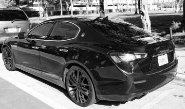 Miami, Florida, ABD - 17 Aralık 2024: Black 2014 Maserati Ghibli spor yara izi. Maserati Ghibli 'nin lüks spor arabası. Maserati Ghibli 'nin arabası dışarıda park edilmiş. Siyah Maserati Ghibli, köşe görünümü.