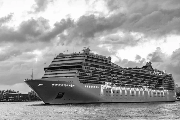 Gece vakti ışıltılı lüks yolcu gemisi yolculuğunun havadan görünüşü. Gemi Miami sahil limanından ayrılıyor. Gemi seyahati. Yaz tatilindeki deniz yolculuğunun havadan görünüşü. Gemi turu ve deniz yolculuğu..