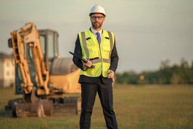 Nesnenin başında şef mühendis var. İnşaat alanı. Erkek mimar. Mühendis müdürü teftiş yapıyor. Mühendislik müfettişi. Bina denetleyicisi tarafından teftiş. Proje detayları.