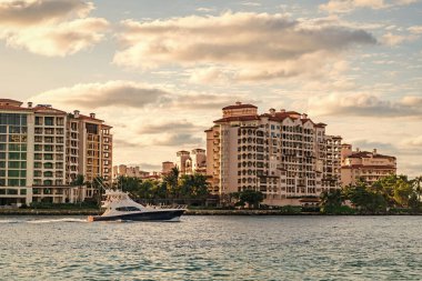 Marinaya yüzen bir tekne. Fisher Adası 'nda lüks bir yat teknesi. Yaz tatili. Fisher Adası konut binası ve lüks yat teknesi. Miami 'de Fisher Adası' na yat gezisi..