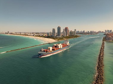 Yük konteynırı kargo gemisine yüklendi. Limandan ayrılan hava görüntülü kargo gemisi. Kargo işi. Konteyner gemisi. Nakliye lojistiği. Ticari nakliye. Kargo gemisi denizde, hava manzaralı..