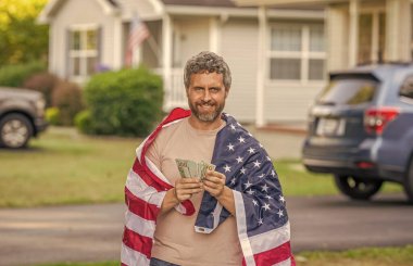 Vergi sistemi. Vatansever adam. Amerikan bayrağı ve dolar parası olan adam. Enflasyon konsepti. Amerikan vergi politikası. İspanyol adam ve Amerikan bayrağı. Amerika 'da vergi ödemek. Katma değer vergisi. Vergi ödemek.