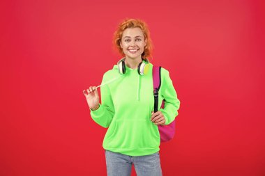 Öğrenci kız sırt çantası taşıyor. Okula dönelim. Bilgi toplama günü. Bilgi ve eğitim. Okul eğitimi. Öğrenci hayatı. Kırmızıda izole edilmiş genç bir kadın. 1 Eylül. Üniversitede okuyorum. Okul projesi.