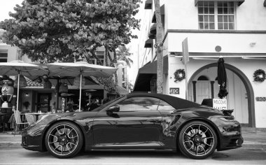 Miami, Florida, ABD - 15 Aralık 2024: Mavi Porsche 992 üstü açık spor araba. Üstü açık Porsche 992 model lüks spor araba. Porsche 992 'nin arabası dışarıda park edilmiş. Porsche 992, yan görüş..