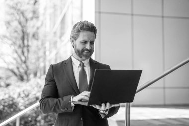 Uzaktan kumanda çalışıyor. İş adamı lideri dışarıda dizüstü bilgisayarda çalışıyor. İş raporlarını kontrol et. Liderlik başarısı. Veriler analiz ediliyor. Serbest çalışan bir iş adamı. Adayları kontrol ediyorum. İş adamı çevrimiçi çalışıyor.