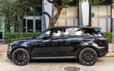 Miami, Florida, ABD - 27 Temmuz 2025: Land Rover Range Sport 2023 SUV arabası. Lüks arazi aracı Land Rover. Otomobil Range Rover 'ı dışarıda park etmiş. Siyah spor SUV araba, yan görüş.