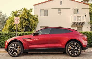 Miami, Florida, ABD - 17 Nisan 2025 Lüks araç Aston Martin DBX. Araba Aston Martin DBX dışarı park edilmiş. Kırmızı araba, yan görüş. Aston Martin DBX 2021 geçiş aracı.
