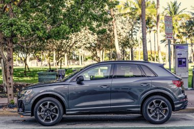 Miami, Florida, ABD - 07 Nisan 2025: Audi Q3 numaralı araba açık havada park edilmiş. Koyu yeşil çapraz araba, yan görüş. 2025 Audi Q3 hibrit coupe crossover araba. Coupe crossover araba Audi Q3.