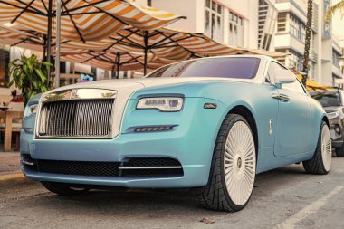 Miami, Florida, ABD - 08 Nisan 2025 Rolls Royce Wraith lüks Grand Tourer arabası. Büyük turnuva arabası Rolls Royce Wraith. Araba Rolls Royce Wraith dışarı park etmiş. Beyaz mavi araba, köşe manzaralı..