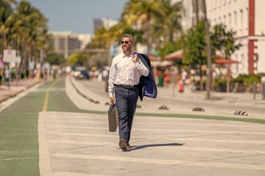 Başarılı bir anlaşmadan sonra bir iş adamı. Şirket işi. Takım elbiseli hırslı bir işadamı. İş portresi. Başarılı bir iş adamı dışarıda evrak çantasıyla dolaşıyor. İş adamı evrak çantasını tutar.