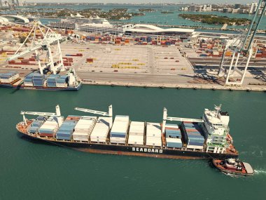 Miami, Florida, ABD - 20 Mart 2025: Kargo gemisi. Miami liman lojistiği. Monrovia konteynırı gemisi. Kargo Seaboard Explorer konteynır gemisi, hava manzaralı. Yük konteynırı kargo gemisi ve römorkör..