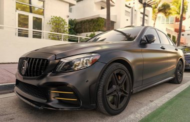 Miami, Florida, ABD - 07 Nisan 2025: Lüks siyah mat Mercedes Benz C W205. Mercedes Benz C W205 dışarıda park halinde. Siyah mat araba, köşe manzaralı. Mercedes Benz C W205 arabası.