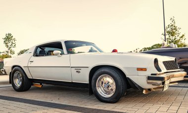 Park Ridge, Illinois, ABD - 21 Ağustos 2024: Otomobil fuarına park edilmiş beyaz araba, köşe manzaralı. Chevrolet Camaro 1976 eski araba. Chevrolet Camaro 'nun beyaz arabası. Chevy Camaro.