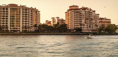 Fisher Adası Binası. Lüks motorlu tekne yatı. Yat marinaya gidiyor. Tekne ve yat gezisi. Lüks bir yaşam tarzı. Fisher Adası 'nda lüks bir binada yat. Yaz tatili. Romantik gün batımı.