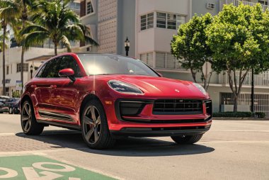Miami, Florida, ABD - 06 Nisan 2025: Porsche Macan açık havada park etti. Kırmızı araba, yan görüş. Porsche Macan 2025 geçiş aracı. Lüks araba Porsche Macan..