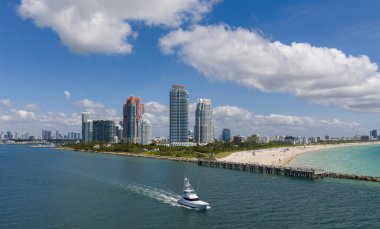 Miami 'de turkuaz sulardaki teknelerin havadan görüntüsü. Miami 'de yat inzivası. Miami 'de yelkenli gemileri olan şehir manzarası