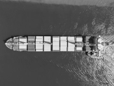 Konteyner gemisi. İhraç ve ithalat. Kargo işi. Nakliye lojistiği. Konteynırlı kargo gemisi, hava manzaralı. Kargo gemisinde nakliye konteynırı. Kargo gemisi limandan ayrılıyor. Ticari gemi.