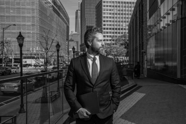 Takım elbiseli zengin adam. Dışarıda başarılı bir iş adamı. İş adamı şehirde başarılı bir toplantı yaptı. İş adamının iş başarısı. Takım elbiseli bir iş adamı. Dizüstü bilgisayarı olan bir yönetici. Yürütme Ofisi.