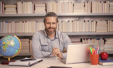 Okulda öğretmenle çevrimiçi eğitim almak sınıfta dizüstü bilgisayarla..