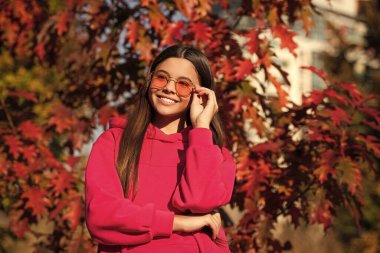 Sonbahar parkındaki genç kız. Sonbahar konsepti. Sonbahar tarzı açık havada bir kız. Sonbahar modası. Sonbahar yaprakları ve ormanda mutlu genç bir kız. Sonbaharın rengi ve havası. Sonbahar titreşimleri.