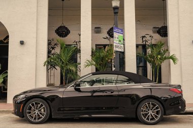 Miami, Florida, ABD - 2 Nisan 2025: BMW 4 serisi 2022 üstü açılabilir coupe araba. Üstü açık lüks BMW 4. Üstü açık BMW 4 arabası dışarıda park edilmiş. Siyah üstü açık araba, köşe manzaralı..