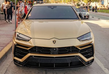 Miami, Florida, ABD - 07 Nisan 2025: Araba Lamborghini Urus açık havada park edilmiş. Altın araba, ön manzara. 2025 Lamborghini Urus hibrit araba. Lüks Melez Lamborghini Urus.