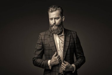 Takım elbiseli şık bir adam. Sakallı bir iş adamı. Gri yolda yabani sakallı adam. Zarif takım elbiseli hırslı bir adam. Erkekler için resmi moda. Erkek giyim modeli. Moda anlayışı.