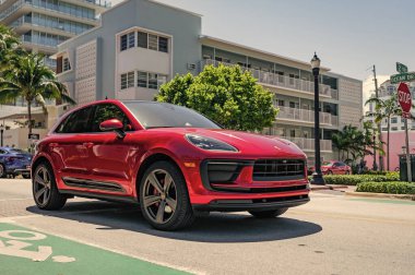 Miami, Florida, ABD - 06 Nisan 2025: Porsche Macan açık havada park etti. Kırmızı araba, yan görüş. Porsche Macan 2025 geçiş aracı. Lüks araba Porsche Macan..