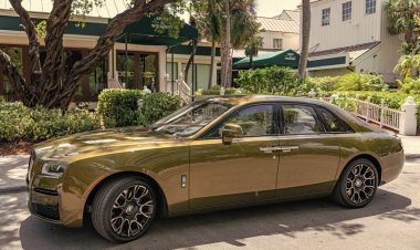 Miami, Florida, ABD - 18 Nisan 2025: Araç 2024 Rolls Royce Ghost açık havada park etti. Altın araba, yan görüş. 2024 Rolls Royce Hayalet sedan arabası. Lüks sedan araba Rolls Royce Hayalet.