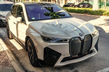 Miami, Florida, ABD - 05 Nisan 2025: Elektrikli çapraz araba BMW IX xDrive50. BMW IX elektrikli SUV dışarıda park halinde. Beyaz araba, köşe manzaralı. 2025 BMW IX xDrive50 lüks elektrikli arazi aracı.