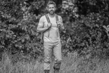 Erkek yürüyüşçü ormanda yürüyor. Sırt çantalı bir gezgin. Yürüyüş macerası. Hayatı dolaştım. Kırsalda yürüyüş yapan bir adam. Ormandaki İspanyol adam. Sırt çantalı bir yürüyüşçü ormanda yürüyüş yapıyor..