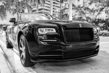 Miami, Florida, ABD - 19 Kasım 2024: 2020 Rolls Royce Dawn üstü açık araba. Lüks siyah Rolls Royce Dawn. Araba Rolls Royce dışarı park etmiş. Rolls Royce, ön manzara..