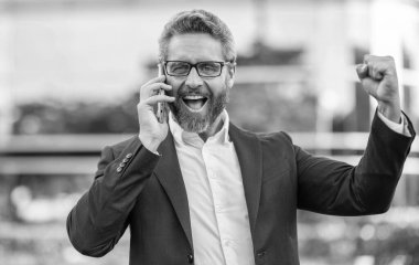 Telefonu olan heyecanlı bir İspanyol iş adamı. İş iletişimi. Müzakere çevrimiçi. İş adamı dışarıda telefonla konuşuyor. Telefon kullanan bir iş adamı. Takım elbiseli adam telefonu..