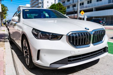 Miami, Florida, ABD - 27 Temmuz 2025 Lüks sedan araç BMW 5. BMW 5 dışarıda park halinde. Beyaz sedan araba, köşe manzaralı. BMW 5 Serisi Sedan 2025 arabası.