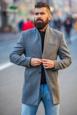Sokakta şık bir işadamı ceketi giyiyor, yaşam tarzı. Şehir tarzı. Şehir sokağı ve şık bir adam. Şehir sokağındaki sakallı adam. Sokaklarda iş adamı stili. Kentsel şehirde iş adamı.
