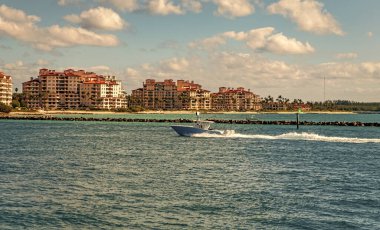 Fisher Adası Binası. Lüks motorlu tekne yatı. Yat marinaya gidiyor. Tekne ve yat gezisi. Lüks bir yaşam tarzı. Fisher Adası 'nda lüks bir binada yat. Yaz tatili. Romantik gün batımı.