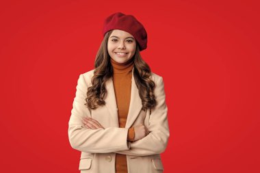 Sonbahar sezonu. Sonbahar modası. Mevsimlik moda tarzı. Kırmızıda izole edilmiş şık bir sonbahar kızı. Sonbahar beresi ve palto giyen genç bir kız. Paltolu sonbahar kızı. Sonbahar ve sonbahar. Ergenlik portresi.