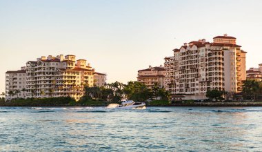 Fisher Adası Binası. Lüks motorlu tekne yatı. Yat marinaya gidiyor. Tekne ve yat gezisi. Lüks bir yaşam tarzı. Fisher Adası 'nda lüks bir binada yat. Yaz tatili. Romantik gün batımı.