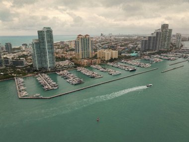 Yat Miami marinasına yanaştı. Miami 'deki kıyı şeridinin havadan görüntüsü. Yelkenli Miamis kıyısı boyunca ilerliyor. Limanın yukarısındaki Miami silueti. Miami 'nin ünlü deniz piyadesi. Yatı olan Marina.
