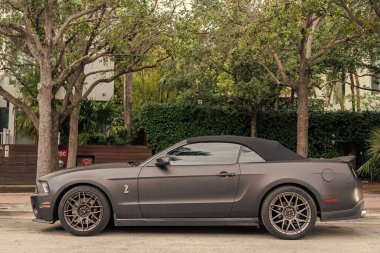 Miami, Florida, ABD - 02 Nisan 2025 üstü açık lüks araba Ford Shelby GT500. Araba Ford Shelby GT500 açık havada park edilmiş. Siyah mat üstü açık araba, yan görüş. 2022 Ford Shelby GT500 üstü açık araba.