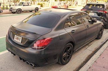 Miami, Florida, ABD - 07 Nisan 2025: Lüks siyah mat Mercedes Benz C W205. Mercedes Benz C W205 dışarıda park halinde. Siyah mat araba, köşe manzaralı. Mercedes Benz C W205 arabası.