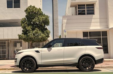 Miami, Florida, ABD - 21 Nisan 2025: 2025 Land Rover Range Sport lüks SUV arabası. Lüks arazi aracı Range Rover. Otomobil Range Rover 'ı dışarıda park etmiş. Beyaz SUV arabası, yan görüş..