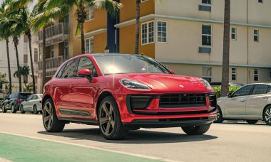 Miami, Florida, ABD - 06 Nisan 2025: Porsche Macan açık havada park etti. Kırmızı araba, yan görüş. Porsche Macan 2025 geçiş aracı. Lüks araba Porsche Macan..