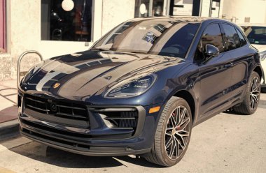 Miami, Florida, ABD - 21 Aralık 2024: Porsche Macan 2020 geçişi koyu mavi araba. Lüks araba Porsche Macan. Araba siyah renkli Porsche Macan dışarıda park etmiş. Porsche Macan, köşe görünümü.